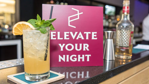 a bar with various cocktails and bottles on the counter