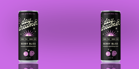 Two cans of 'day dreamer' berry bliss sparkling water on an purple background