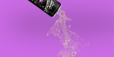 a black and purple can of Day Dreamer Cannabis sparkling water pouring out in front of a purple background