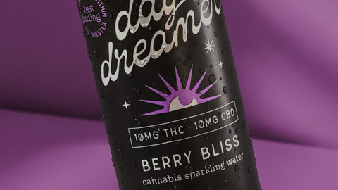 Cannabis sparkling water bottle labeled 'day dreamer' with 'Berry Bliss' flavor on a purple background.
