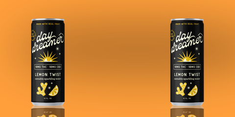 Two cans of 'day dreamer' lemon twist sparkling water on an orange background