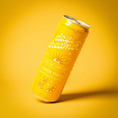 Yellow can of 'day dreamer' lemon twist sparkling water on a yellow background